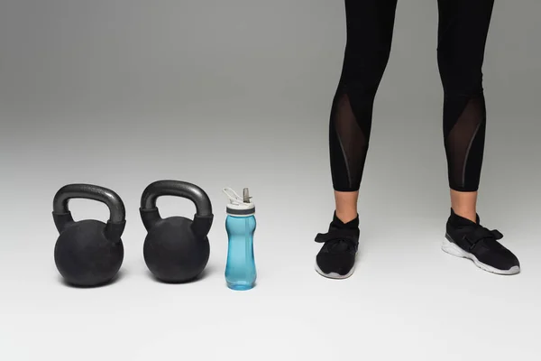 Cropped View Sportswoman Black Leggings Kettlebells Sports Bottle Grey Background — 图库照片