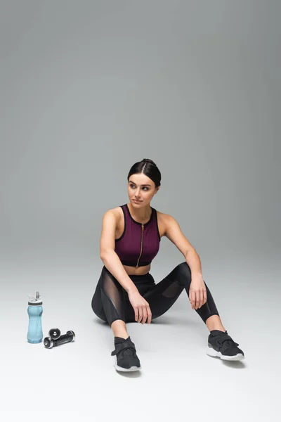 Woman Black Leggings Sitting Dumbbells Sports Bottle Grey Background — 스톡 사진