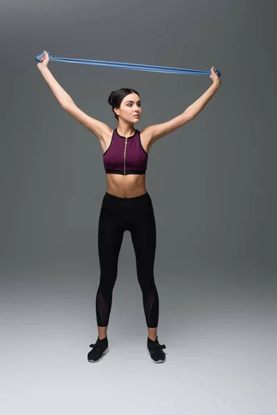 Full Length View Slim Sportswoman Training Resistance Band Grey Background — Stock Photo, Image
