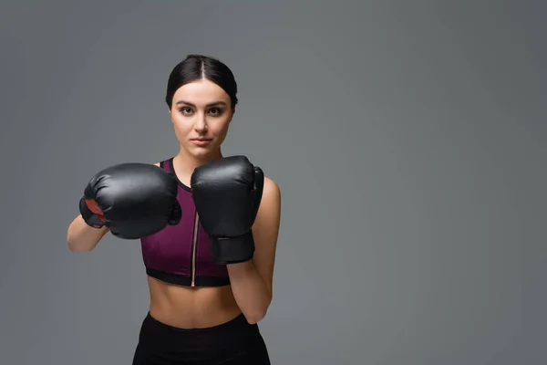 Vrij Sportvrouw Kijken Naar Camera Tijdens Het Boksen Geïsoleerd Grijs — Stockfoto