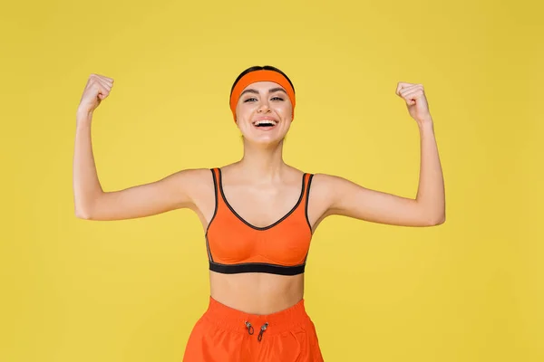 Cheerful Sportswoman Demonstrating Strength While Smiling Camera Isolated Yellow — Foto de Stock