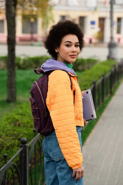 Afroamerikanerin Jacke Hält Laptop Der Hand Und Blickt Die Kamera — Stockfoto