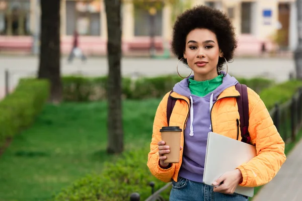 Femeie Afro Americană Uită Cameră Timp Ține Ceașcă Hârtie Laptop — Fotografie, imagine de stoc