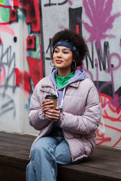 Hübsche Afroamerikanerin Hält Imbissgetränk Auf Bank Der Nähe Von Graffiti — Stockfoto