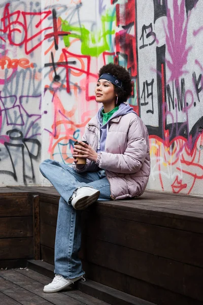 Mujer Afroamericana Sosteniendo Café Mientras Está Sentada Banco Cerca Del — Foto de Stock