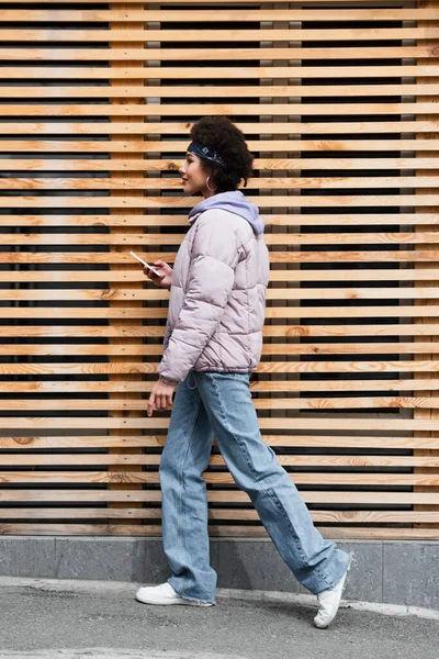Ahşap Çitlerin Yanında Akıllı Telefonlu Modaya Uygun Afro Amerikan Kadın — Stok fotoğraf