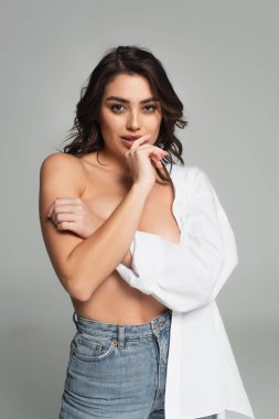 Çıplak göğsünü kapatan şehvetli kadın, gri renkte izole edilmiş. 