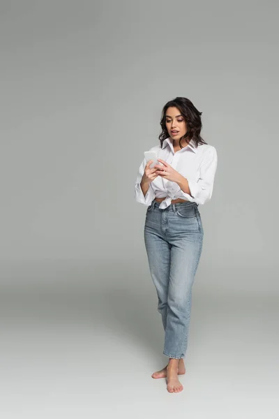 Pretty Brunette Woman Shirt Jeans Using Smartphone Grey Background — Stock Photo, Image