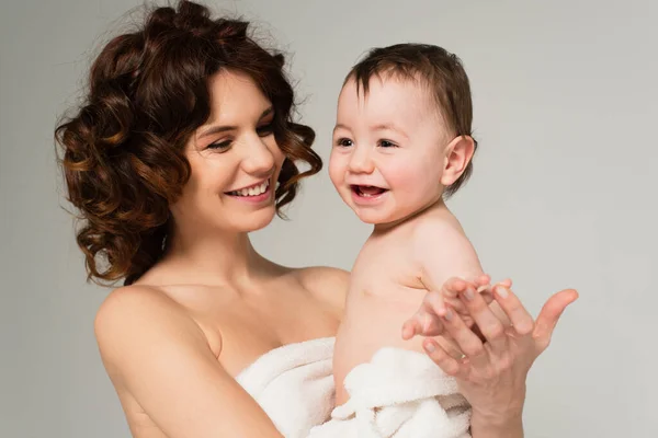 Cheerful Curly Mother Bare Shoulders Holding Arms Son Towel Isolated — Stock Photo, Image