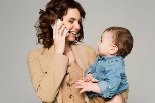 Gelukkig Moeder Praten Mobiele Telefoon Houden Armen Baby Jongen Geïsoleerd — Stockfoto