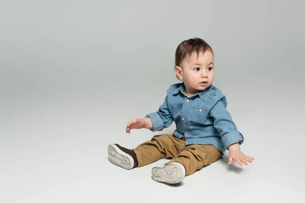Menino Criança Camisa Jeans Calças Bege Sentado Cinza — Fotografia de Stock