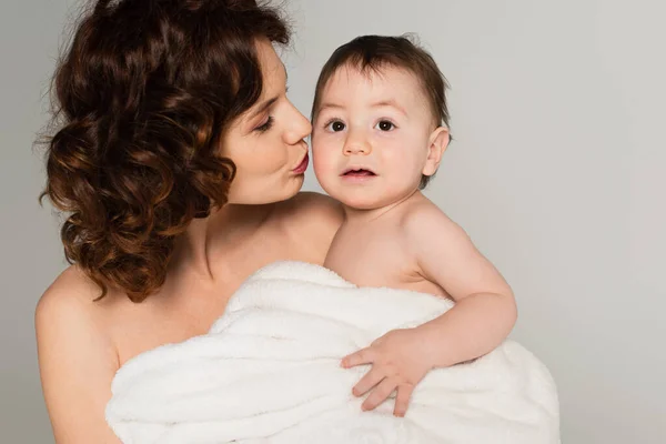Caring Mother Bare Shoulders Kissing Baby Boy Wrapped Towel Isolated — Stock Photo, Image