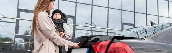 Jovem Mãe Segurando Criança Perto Automóvel Banner — Fotografia de Stock