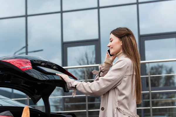 Ładna Kobieta Rozmawia Przez Telefon Komórkowy Pobliżu Bagażnika Samochodu — Zdjęcie stockowe