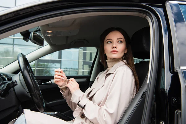 Trençkotlu Güzel Kadın Arabada Otururken Gözlerini Kaçırıyor — Stok fotoğraf