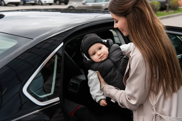 Jovem Mãe Colocando Bebê Menino Automóvel — Fotografia de Stock