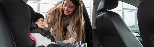 Feliz Mujer Cerca Toddle Hijo Sentado Coche Asiento Bebé Bandera — Foto de Stock