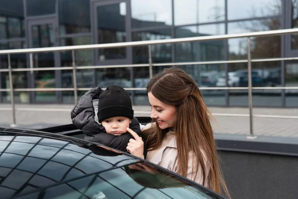 Sonriente Mujer Tocando Mejilla Bebé Niño Cerca Coche Aire Libre — Foto de Stock