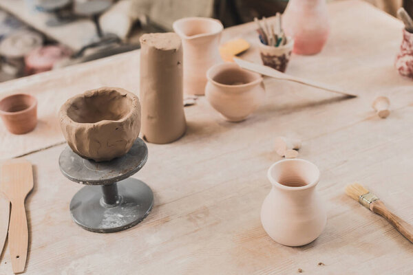 high angle view of sculpted clay bowl on wooden table in pottery