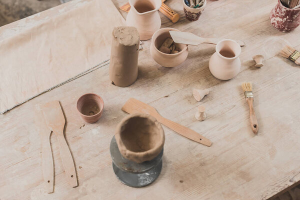 high angle view of sculpted clay bowl on wooden table in pottery