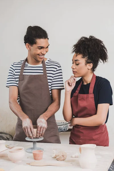 アフリカ系アメリカ人の若い男が陶器の顔の近くで女性の近くで土鍋を作っています — ストック写真