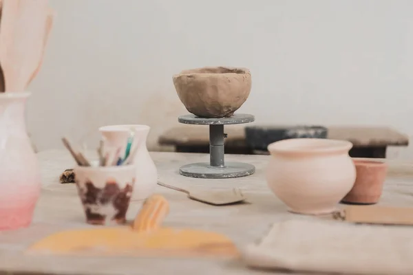 sculpted clay bowl on wooden table in pottery art studio