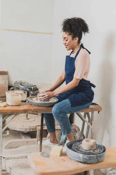 Улыбающаяся Молодая Африканская Американка Моделирующая Мокрую Глину Колесах Руками Керамике — стоковое фото