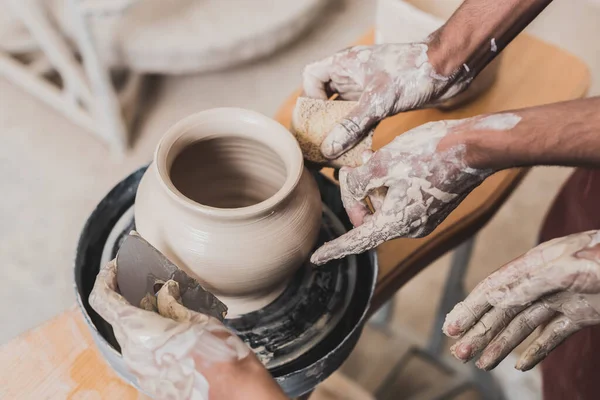 若いアフリカ系アメリカ人のカップルが陶器の手とスクレーパーでホイールにぬれた土鍋を作っている様子を間近で見られます — ストック写真