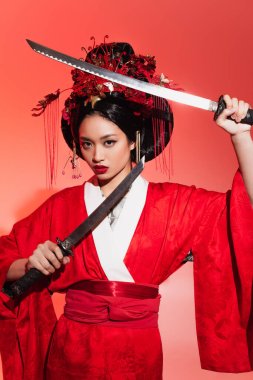Japanese woman in red kimono holding swords on red background  clipart