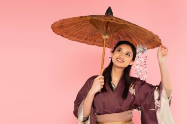 Geleneksel elbiseli mutlu Japon kadın pembe şemsiye altında duruyor. 