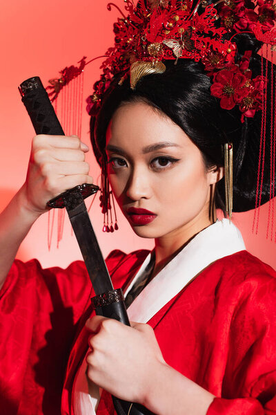 Portrait of asian woman with sword and sheath on red background 