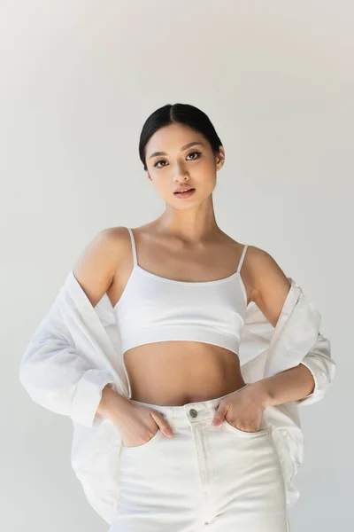 Jovem Mulher Asiática Mãos Dadas Bolsos Calças Isoladas Cinza — Fotografia de Stock