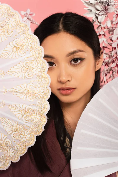 Japonesa Mujer Mirando Cámara Cerca Fans Aislados Rosa — Foto de Stock