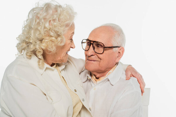 happy elderly couple gently hugging isolated on white