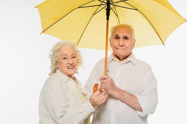 Счастливая Пожилая Пара Держит Желтый Зонтик Изолирован Белом — стоковое фото