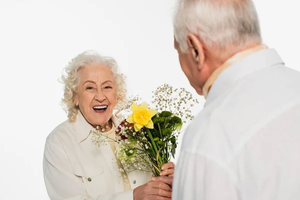 Sorrindo Mulher Idosa Segurando Buquê Flores Perto Marido Borrado Isolado — Fotografia de Stock