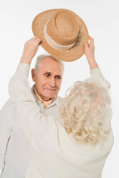 Elderly Woman Putting Hat Head Smiling Husband Isolated White — Stock Photo, Image