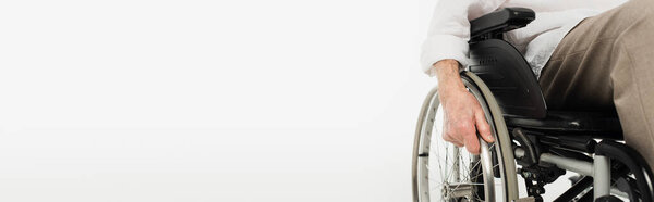 partial view of elderly man sitting in wheelchair isolated on white, banner