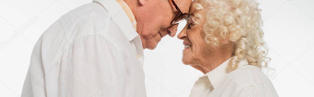 elderly couple gently touching with heads isolated on white, banner