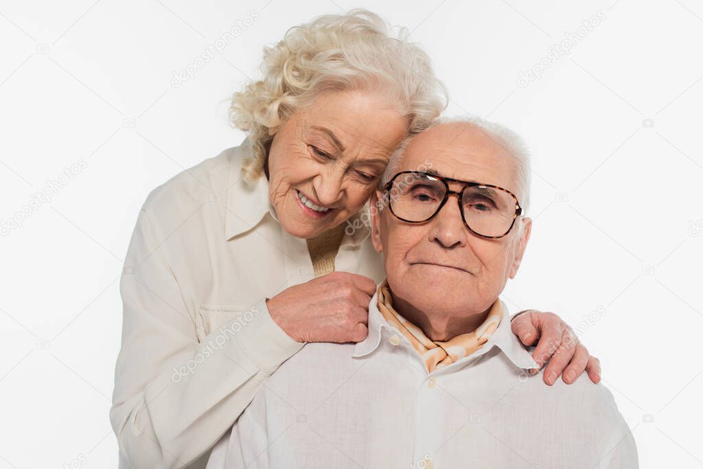 elderly woman gently hugging husband isolated on white