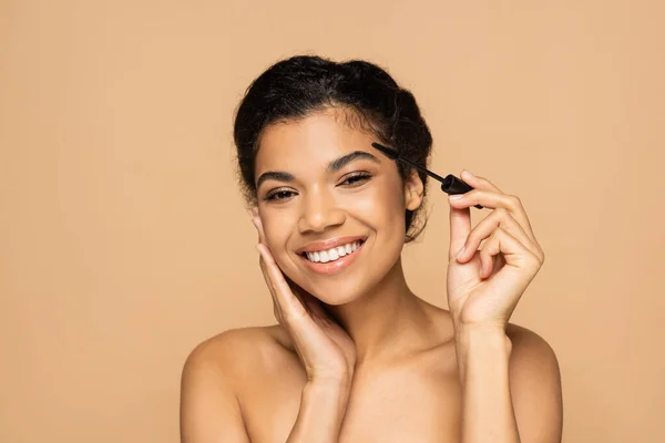 Cheerful African American Woman Bare Shoulders Applying Mascara Isolated Beige — Stock Photo, Image
