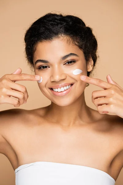 Joyful African American Woman Pointing Face Cream Cheeks Isolated Beige — Stock Photo, Image