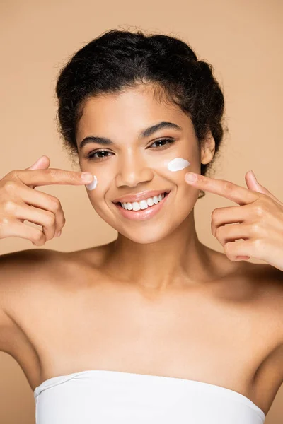 Alegre Afroamericana Mujer Apuntando Cara Crema Mejillas Aislado Beige — Foto de Stock