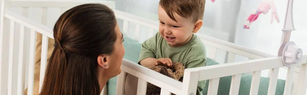 Enfant Souriant Avec Jouet Doux Regardant Mère Dans Chambre Bannière — Photo