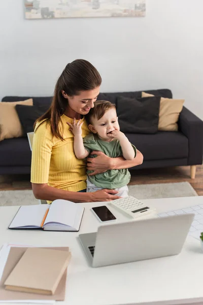 Smiling Freelancer Hugging Son Devices Notebooks Home — Stock Photo, Image