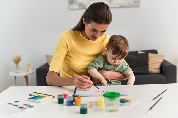 Leende Mor Målning Med Småbarn Son Nära Suddig Färg Borstar — Stockfoto