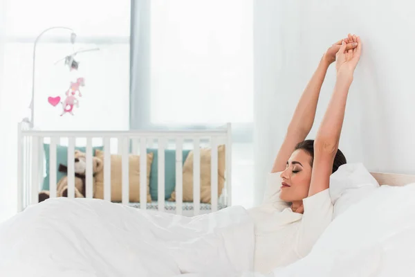 Vista Laterale Della Giovane Donna Che Estende Sul Letto — Foto Stock