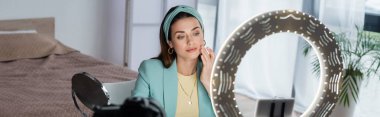 Genç güzellik blogcusu telefon kılıfında akıllı telefonun yanına dokunuyor.