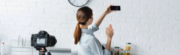 Housewife Waving Hand Smartphone Blank Screen Blurred Digital Camera Kitchen — Stock Photo, Image