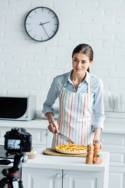 Размытая Цифровая Камера Рядом Кулинарным Блогером Ножом Рядом Вкусным Пирогом — стоковое фото